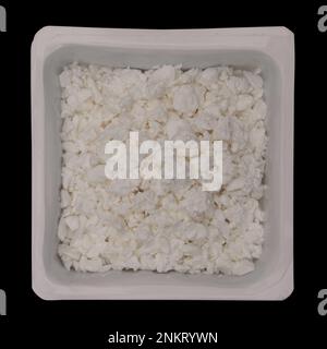 Ricotta formaggio in contenitore isolato su sfondo nero. Vista dall'alto. Latticini freschi Foto Stock