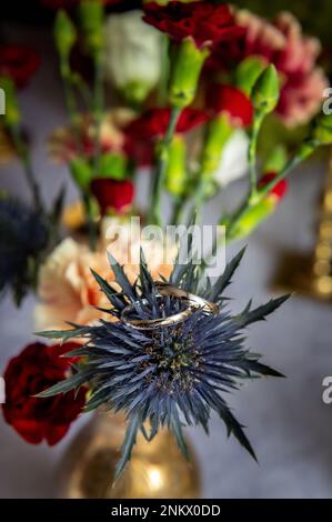 fiori bouquet bouquet e boutonnieres un bouquet di fiori con anelli in piedi in vaso sul tavolo Foto Stock