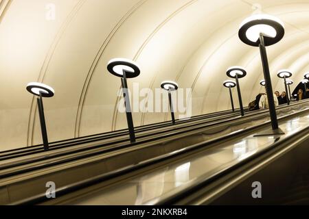 Mosca, Russia - 22 febbraio 2023: Lunga scala mobile con persone della stazione della metropolitana Michurinsky Prospekt nella città di Mosca Foto Stock