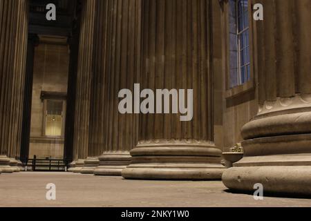 Basso angolo di pilastri di fronte al British Museum di notte senza nessuno. Museo o classico greco colonne concetto sfondo o risorsa grafica Foto Stock