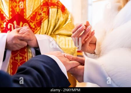 mani, anelli di nozze e voti di matrimonio la sposa tiene e mette un anello di nozze sul dito dello sposo Foto Stock