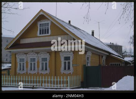 La casa di tronchi a destra dell'Embankment #24 a Ustiuzhna, costruita nel XX secolo, è un esempio di architettura tradizionale russa in legno. Riflette le tecniche di costruzione e l'artigianato locali. Foto Stock