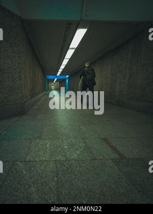 uomo nel tunnel sotterraneo della stazione ferroviaria Foto Stock