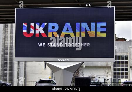 Un cartellone elettronico a Manchester (Regno Unito), il 24th febbraio 2023, segna il primo anniversario dell'invasione illegale dell'Ucraina da parte della Russia, con L'UCRAINA nei colori delle bandiere inglesi e ucraine e un messaggio "We Stand Together". Foto Stock