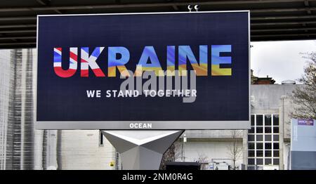 Un cartellone elettronico a Manchester (Regno Unito), il 24th febbraio 2023, segna il primo anniversario dell'invasione illegale dell'Ucraina da parte della Russia, con L'UCRAINA nei colori delle bandiere inglesi e ucraine e un messaggio "We Stand Together". Foto Stock