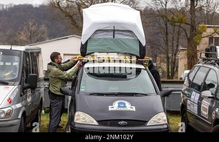 Dresda, Germania. 24th Feb, 2023. Un uomo fissa il posto letto per le notti sul tetto della sua Ford durante l'evento stampa prima dell'inizio del 33rd° Rally Dresden-Dakar-Banjul presso il cantiere Laubegast. Il Rally Dresda-Dakar-Banjul inizia il 25 febbraio 2023 a Hohnstein (Sassonia) con la destinazione Gambia, dove i veicoli saranno messi all'asta e i proventi donati alla ONG "Dresden-Banjul Organization". Credit: Daniel Schäfer/dpa/Alamy Live News Foto Stock