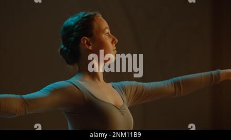 Ripresa cinematografica di una bella ballerina classica femminile in abito tutu bianco che balla sul palco del teatro e si prepara ad iniziare lo spettacolo. Coreografia prima dell'inizio dello spettacolo. Balletto classico art. Foto Stock