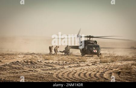 Il corpsman per Bridge Platoon, Alpha Company, 9th Engineer Support Battalion, dirige i cucciolieri mentre caricano una Marina infortunata in un elicottero durante un'evacuazione medica nel distretto di Garmsir, nella provincia di Helmand Foto Stock