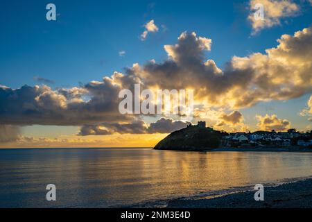 Il castello di Criccieth sulla penisola di Llyn con il sole che tramonta dietro in una giornata d'inverni Foto Stock