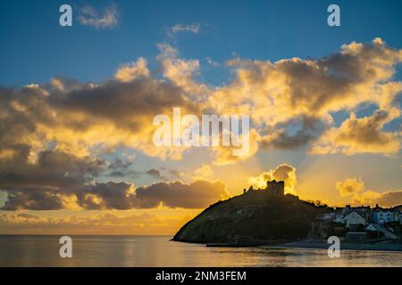 Il castello di Criccieth sulla penisola di Llyn con il sole che tramonta dietro in una giornata d'inverni Foto Stock