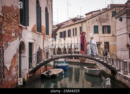 Ritratto di un paio di maschere carnevale a Venezia su un tipico ponte Foto Stock