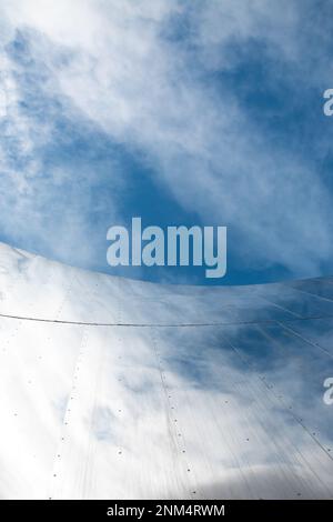 Vista dall'angolo basso dell'architettura astratta della facciata della stazione ferroviaria di Birmingham New Street con curve metalliche e linee pulite e cielo blu di riferimento Foto Stock