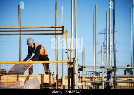 Operai di costruzione che costruiscono le nuove sedi sul luogo Foto Stock