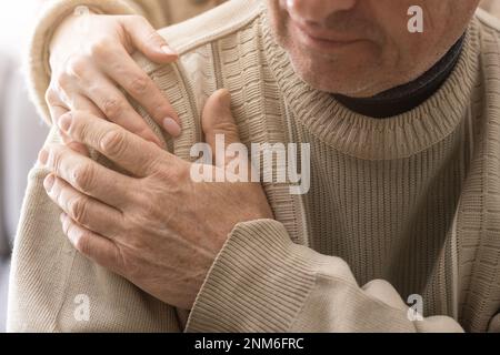 Testa ha sparato vecchio pensionato maschio coinvolto nella procedura di riabilitazione con giovane fisioterapista premuroso. uomo in pensione con sensazione di disabilità motoria Foto Stock