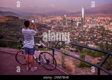 Panorama di Santiago (edifici Providencia e la torre Gran Torre Santiago) e Ande Montagne da Cerro San Cristobal, Santiago, Cile Foto Stock