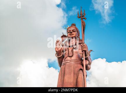 Statua enorme Shiva Mangal Mahadev è un pezzo d'arte di 33 m nel tempio di Ganga talao sul cielo nuvoloso blu, isola Mauritius. Foto Stock