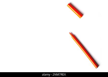 Una penna arancione con punta in feltro e cappuccio si trova su uno sfondo bianco. spazio vuoto per la scrittura Foto Stock