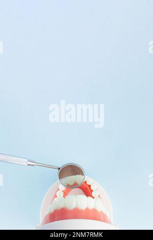 Falsi denti con specchio dentista della bocca, mascelle. Concetto di controllo degli strumenti odontoiatrici e dell'igienista dentale. Foto Stock