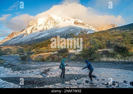 Gli escursionisti Varcando il fiume e passeggiate tra Torres e rifugio Rifugio Cuernos, parco nazionale Torres del Paine, Patagonia, Cile Foto Stock