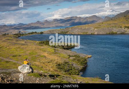 Escursionista di scattare una foto, tra Torres e rifugio Rifugio Cuernos, parco nazionale Torres del Paine, Patagonia, Cile Foto Stock