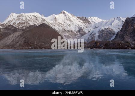 Pittoresca montagna Cho Oyu che si riflette nel lago morenico blu coperto di ghiaccio. Bella montagna paesaggio Parco Nazionale Sagarmatha, Himalaya, N Foto Stock