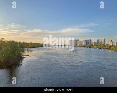 Splendida vista panoramica della città del fiume Kyiv Dneper al tramonto su acqua blu scuro con i raggi luminosi riflessi del sole, copia-spazio. Vista di Foto Stock