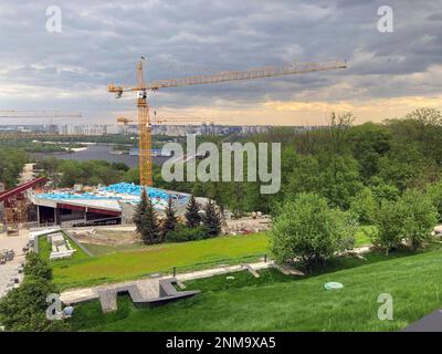 Cantiere, tre gru a torre alta e materiali da costruzione blu. Memoriale alle vittime dell'Holodomor in Ucraina. Una visione della costruttio Foto Stock