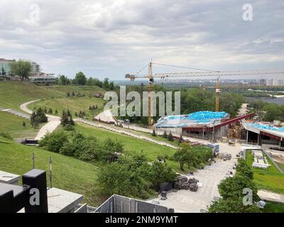 Cantiere, tre gru a torre alta e materiali da costruzione blu. Memoriale alle vittime dell'Holodomor in Ucraina. Una visione della costruttio Foto Stock