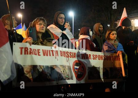 Varsavia, Varsavia, Polonia. 24th Feb, 2023. I cittadini bielorussi hanno una bandiera che legge ''il commercio con la Russia eguaglia la Sponsorizzazione di guerra'' mentre prendono parte ad un raduno che segna il primo anniversario dell'aggressione russa dell'Ucraina il 24 febbraio 2023 a Varsavia, Polonia. Centinaia di persone si sono radunate al di fuori dell'ambasciata russa per protestare contro l'aggressione russa su vasta scala che dura tutto l'anno contro l'Ucraina e commemorare coloro che hanno perso la vita. (Credit Image: © Aleksander Kalka/ZUMA Press Wire) SOLO PER USO EDITORIALE! Non per USO commerciale! Foto Stock