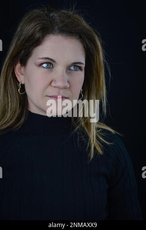 ritratto di una bella donna bionda che guarda via con uno sguardo serio e severo Foto Stock