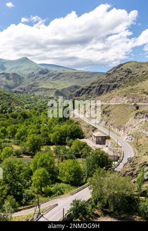 Tortuosa strada asfaltata (storica strada di seta) attraverso il villaggio di Khertvisi nella valle del fiume Mtkvari nelle montagne del Caucaso minore, nella regione di Samtskhe - Javakheti, Foto Stock