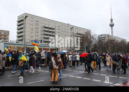Berlino, Germania. 24th Feb, 2023. I manifestanti con bandiere ucraine si sono riuniti di fronte al caffè Mosca, temporaneamente rinominato caffè Kyiv durante la dimostrazione. A Berlino, in Germania, si è svolta una grande manifestazione contro la guerra. La manifestazione è iniziata alle 4 presso Karl-Marx-Alee 34 e si è spostata verso ovest verso la porta di Brandeburgo. (Foto di Takimoto Marina/SOPA Images/Sipa USA) Credit: Sipa USA/Alamy Live News Foto Stock