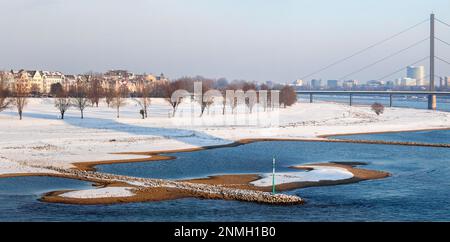 Vista sulla riva del Reno dell'Oberkassel nella neve dal ponte Rheinknie, Duesseldorf, Renania settentrionale-Vestfalia, Germania Foto Stock