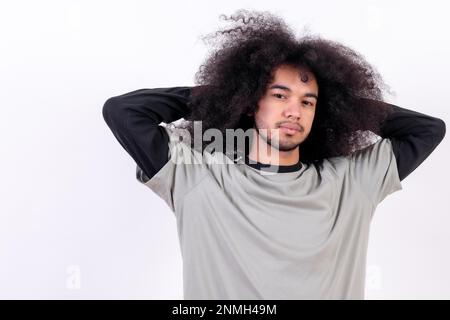 Allungamento e risveglio dei ritratti. Giovane uomo con capelli afro su fondo bianco Foto Stock
