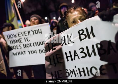 I manifestanti sono in possesso di cartelli che esprimono la loro opinione durante la protesta contro la guerra a Varsavia. Migliaia di polacchi, ucraini e bielorussi si si sono riuniti fuori dall'ambasciata russa a Varsavia per protestare contro l'aggressione della Russia contro l'Ucraina e per dimostrare solidarietà con l'Ucraina, in occasione dell'anniversario dell'assalto. I manifestanti stavano tenendo le loro bandiere nazionali e anche i segni con i nomi scritti degli ucraini caduti nella guerra. La folla si è poi recata al parlamento per esercitare pressioni affinché continuasse a sostenere l'Ucraina e condannasse la guerra. Foto Stock