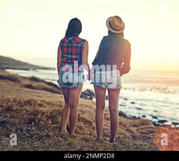 I migliori amici fanno per le migliori estati. due giovani amici si fermano in spiaggia per ammirare la vista durante il loro viaggio in auto. Foto Stock