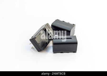 Batterie ricaricabili con caricabatterie isolato su sfondo bianco Foto Stock