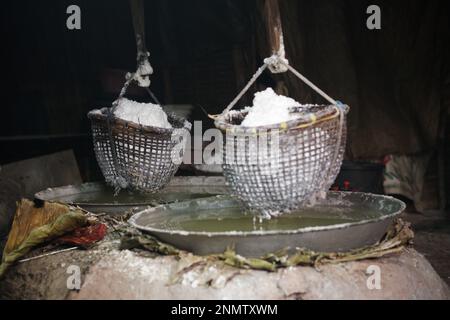 bollire soluzione salina in padella è il modo tradizionale per fare sale di montagna roccia Foto Stock