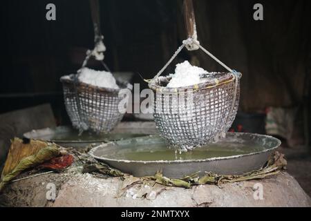 bollire soluzione salina in padella è il modo tradizionale per fare sale di montagna roccia Foto Stock