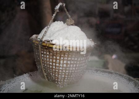 bollire soluzione salina in padella è il modo tradizionale per fare sale di montagna roccia Foto Stock