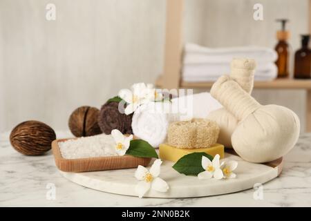 Composizione con bellissimi fiori di gelsomino e sale marino su tavola in marmo bianco all'interno Foto Stock