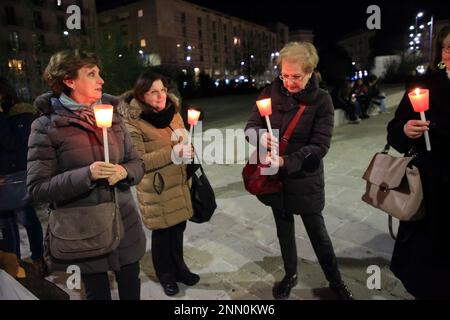 Persone con bandiere di pace , segni di protesta e torce partecipano a un incontro e marcia per chiedere la fine della guerra in Ucraina. Foto Stock