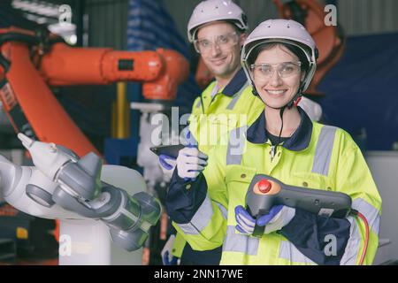 felice team di ingegneri ritratto pollici godere di lavorare insieme in moderna fabbrica di metallo con braccio robotico Foto Stock