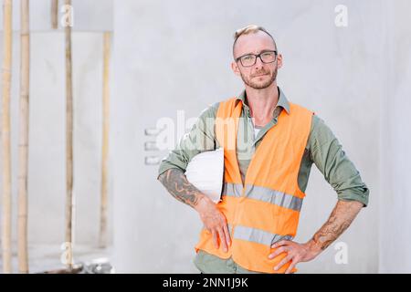 costruttore di ritratti ingegnere professionista architetto caposquadra lavoratore hipster lavoro in cantiere, guardando sicuro fotocamera Foto Stock