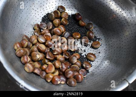 Molte castagne roastin macchina nel mercato notturno vietnamita a da Lat Foto Stock