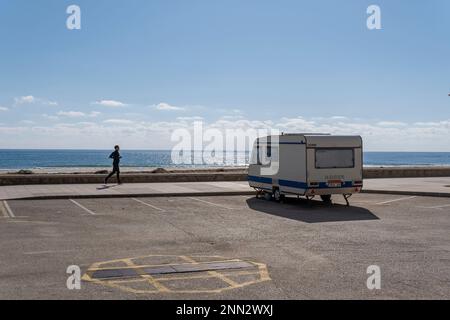 SA Coma, Spagna; 17 2023 febbraio: Caravan parcheggiato sul lungomare della località turistica di SA Coma in una mattinata di sole, con un uomo che gioca a sport. Probl Foto Stock