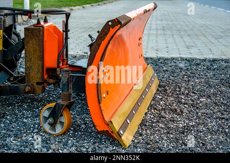 Benna da neve arancione. Spazzaneve di piccole dimensioni. Attrezzatura per la rimozione della neve in previsione dell'inverno. Primo piano. Messa a fuoco selettiva. Spazio di copia. Foto Stock