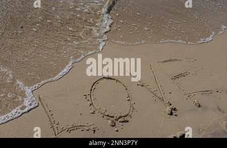 Iscrizione Amore disegnato sulla sabbia. Concetto di sentimenti romantici sinceri e onesti. spa romanzo sul mare. Foto Stock