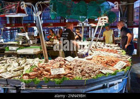 Le persone che acquistano il pescato del giorno sotto la Loggia del mercato ittico nel sestiere di San Polo, Rialto mercato, Venezia, Veneto, Italia Foto Stock