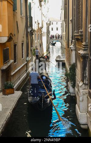 Gondole sul canale stretto del Rio de San Salvador con il ponte ad arco Ponte Manin che si affaccia sul Canal Grande sullo sfondo, Venezia, Italia Foto Stock